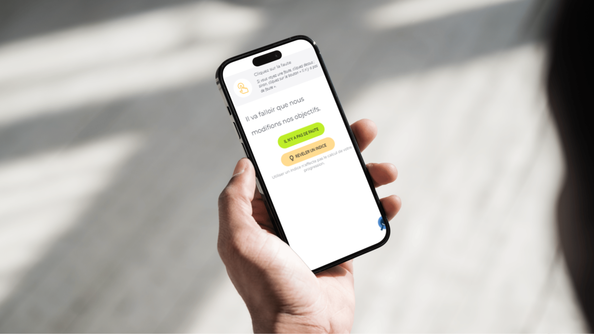 Une main tient un smartphone affichant un exercice d’orthographe du Projet Voltaire où il faut trouver la faute.