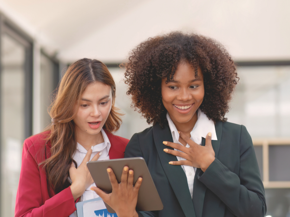 Deux collègues sont surprises en lisant sur leur tablette.