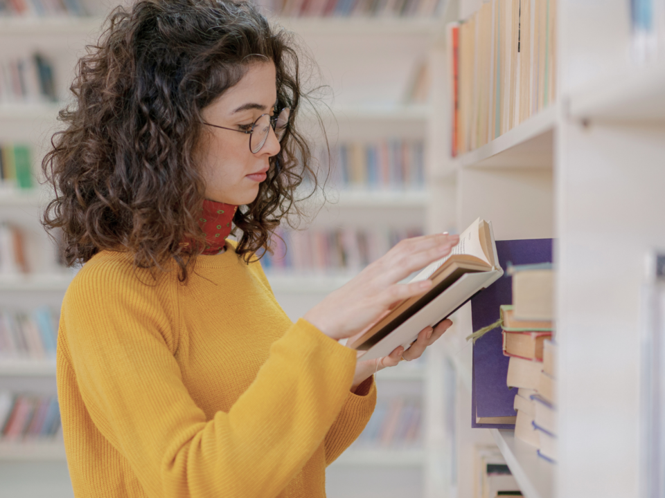 Une femme lit dans une bibliothèque.