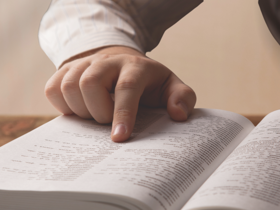 Un homme lit un dictionnaire.