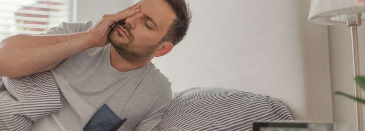 Un homme se lève difficilement de son lit.