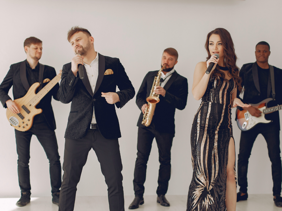 Un groupe de musique joue, accompagné d'une chanteuse.