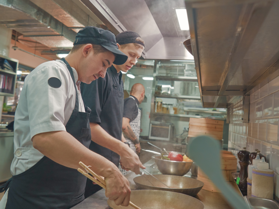 Des cuisiniers préparent des plats.