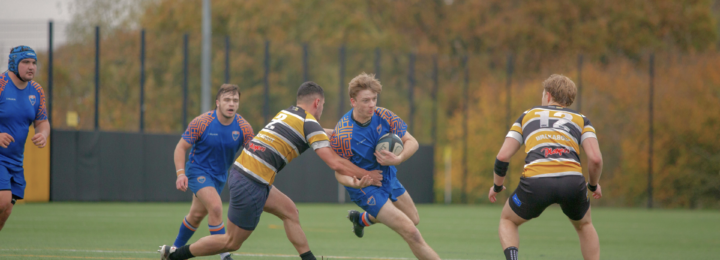 Cinq joueurs de rugby sont en plein match.