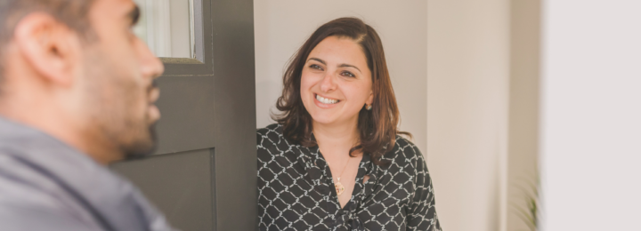 Une femme reçoit un invité chez elle.
