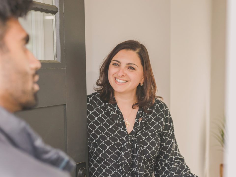 Une femme reçoit un invité chez elle.