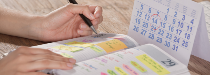 Une personne écrit dans son agenda.