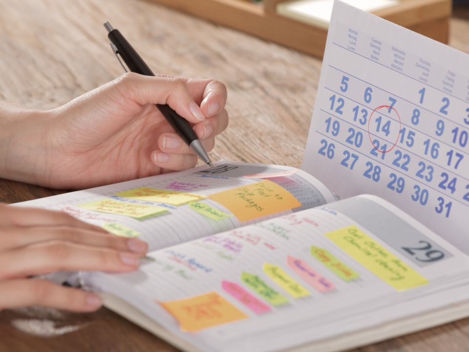 Une personne écrit dans son agenda.