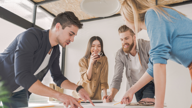 Groupe de jeunes professionnels collaborant autour d'une table lors d'une réunion créative au bureau.
