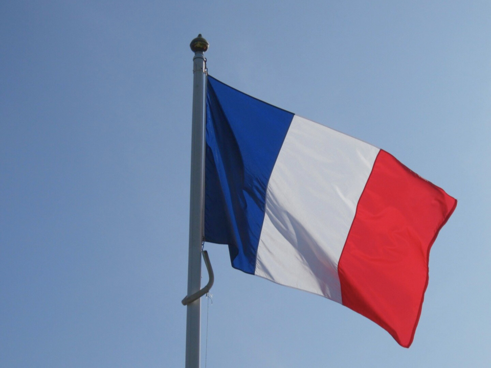 Un drapeau français vole au vent.